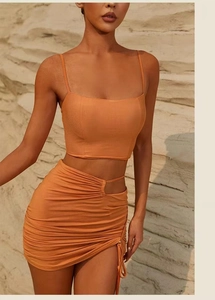Detail view of orange yoga set showing hollow waist design and side drawstring slit skirt