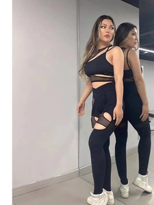Dettaglio dei pantaloni da yoga neri con inserti in rete e tagli sexy sulle gambe
