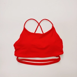 Dettaglio di reggiseno sportivo rosso con spalline incrociate e vita con cut-out