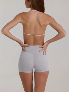 Vista posteriore degli shorts da yoga grigi a vita alta e reggiseno sportivo rosa