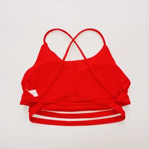 Dettaglio del reggiseno sportivo rosso con spalline incrociate ed etichetta taglia S
