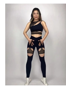 Dettaglio completo yoga nero con top asimmetrico e leggings con inserti in mesh trasparente