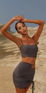 Detail of ruched drawstring skirt and cutout side on a grey yoga activewear set