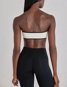Back view of a white sports bra with black piping and high-waist yoga leggings