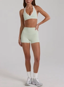 Dettaglio del set yoga verde menta con reggiseno sportivo a V e pantaloncini a vita alta