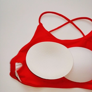 Dettaglio delle imbottiture bianche rimovibili e delle tasche del reggiseno sportivo rosso
