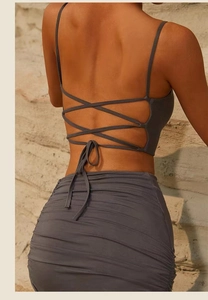Detail of dark grey cross-back yoga set featuring side drawstring skirt and ribbed fabric