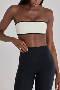 Detail view of white bandeau sports bra with black contrast trim and high elastic fabric