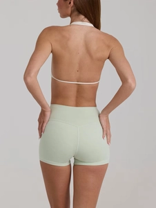 Dettaglio posteriore degli shorts da yoga verde chiaro a vita alta con taglio sportivo