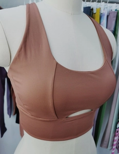 Detail of high elasticity sports bra featuring front cutout and U-neck in brick red
