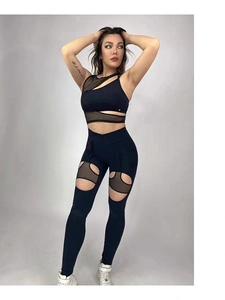 Dettaglio dei pantaloni da yoga neri con inserti in mesh e ritagli laterali curvi