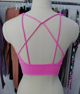 Detailed back view of a pink sports bra featuring elastic cross-strap design for yoga