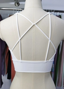 Detailed back view of white sports bra featuring a cross-strap cutout aesthetic design