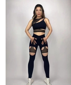 Dettaglio degli inserti in mesh e ritagli sui pantaloni da yoga neri a vita alta