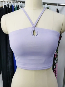 Détail d'un haut de yoga violet clair avec décolleté ajouré sur un mannequin beige de face