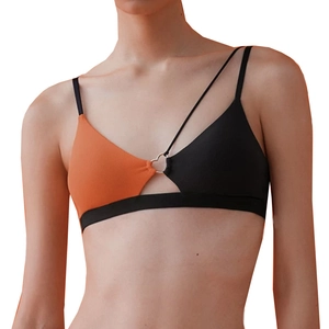 Detail of ribbed sports top with heart-shaped metal ring and orange-black color contrast