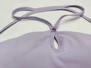 Détail de la brassière de sport lavande avec coutures soignées et découpe goutte