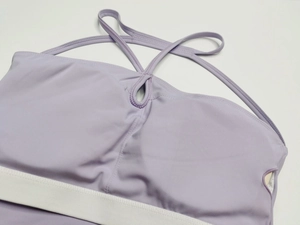 Détail de la brassière de yoga violette avec ouverture et fines bretelles croisées