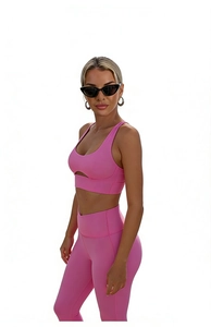 Detailed view of pink sports bra with cut-out front and high-waist yoga leggings