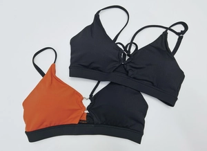 Detail view of workout tops featuring thin straps and center metal ring connector