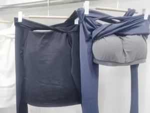 Detail of off-shoulder yoga long sleeve top featuring inner chest pads and cross knot neckline