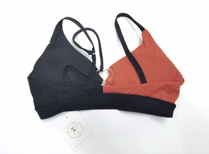 Detail of two-tone sports bra with silver heart ring connector and thin straps