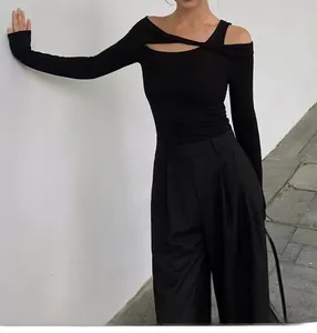 Detail of black off-shoulder yoga top featuring a unique cutout twist knot design
