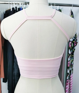 Détail du haut de yoga rose clair avec dos évidé et fines bretelles de sport
