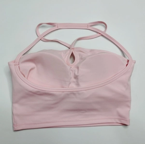 Détail de brassière de yoga rose avec découpe goutte d'eau et bretelles croisées
