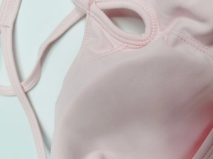 Détail du tissu du débardeur de yoga rose avec design ajouré et coutures renforcées