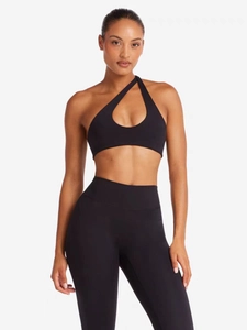 Détail de la brassière de sport noire asymétrique et du legging de yoga à taille haute
