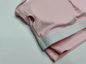 Détail du soutien-gorge de sport rose clair montrant l'insertion du rembourrage amovible