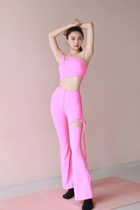 Detail of hot pink yoga jumpsuit showing one-shoulder cut and side drawstring lacing