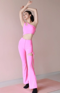 Detail of hot pink one-shoulder yoga top and flare pants with drawstring hollow-out