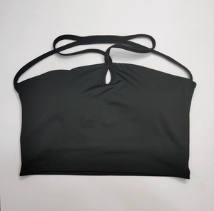 Détail du haut de yoga noir avec décolleté goutte d'eau et structure à brides multiples