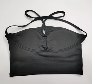 Détail d'une brassière de yoga noire avec découpe croisée et tissu mat hautement élastique