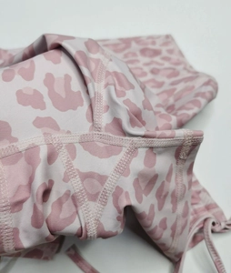 Detailansicht der rosa Yoga-Hose mit Leopardenmuster und flachen Vier-Nadel-Sechs-Faden-Nähten