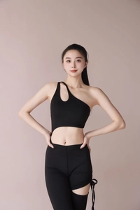 Detail of black one-shoulder yoga jumpsuit featuring side cutout and drawstring design