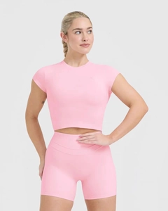 Close-up of slim-fit pink yoga top with high-stretch fabric and geometric logo