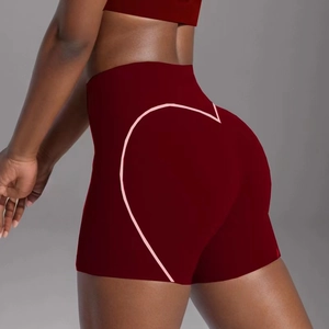 Close-up of high-waisted burgundy yoga shorts with pink heart-shaped peach lift detail