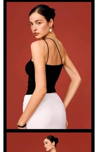 Close-up of a black one-shoulder yoga vest featuring stylish stone detail and a chic open back
