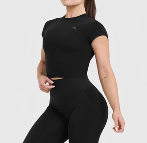 Detail of black slim-fit crop top and high-waisted yoga pants with silver logo detail