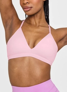 Close-up of light pink V-neck sports bra with thin straps and wide elastic band