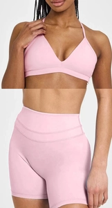 Detail of pink V-neck sports bra and high-waisted seamless shorts for yoga workout