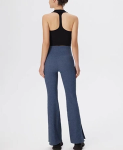 Detail view of high-waist flared yoga pants with side slits and elastic sport fabric