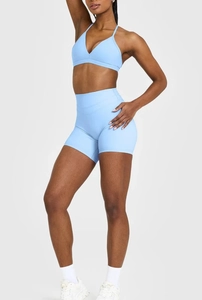 Nahaufnahme hellblauer Sport-BH mit schmalen Trägern und passender hoher Fitness-Shorts