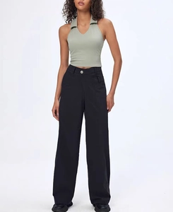 Detail view of a sage green polo neck yoga vest paired with black high-waisted pants