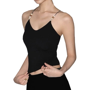 Detail des schwarzen Yoga-Tops mit überkreuzten Trägern und dekorativen Holzperlen