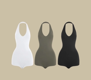 Flat lay view of deep V-neck halter jumpsuits in white, green, and black colors