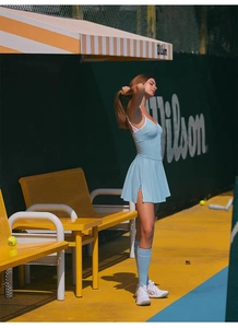 Detalle de vestido de yoga azul claro con tirantes blancos y abertura lateral